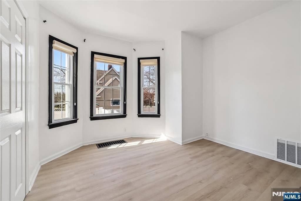 11 Garden Street, Unit 1 Ridgefield Park, NJ 07660 - Photo 8 of 20 an empty room with wooden floor and windows