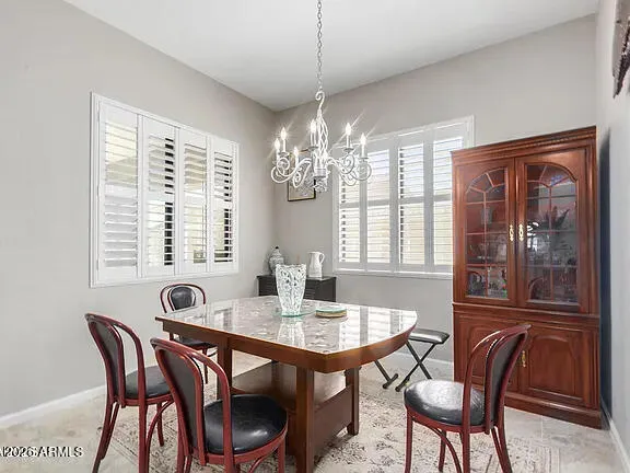 a dining room with furniture a chandelier and window