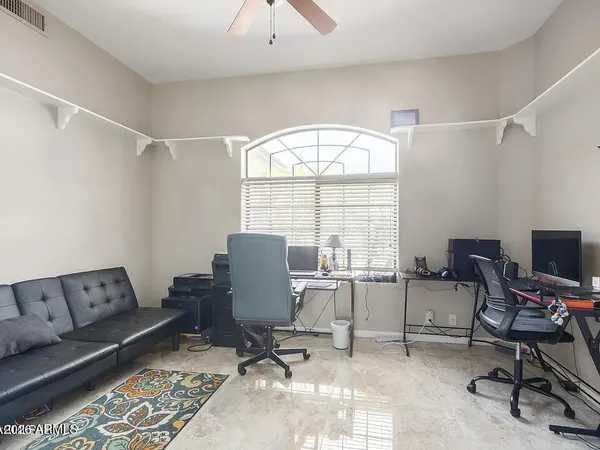 a view of a workspace with furniture and a window