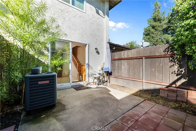 a view of a patio with table and chairs with wooden fence and plants