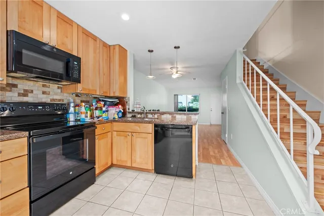 a kitchen with stainless steel appliances granite countertop a refrigerator a sink a stove top oven and cabinets