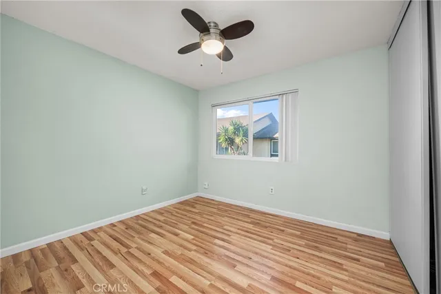 a view of a big room with wooden floor and a ceiling fan