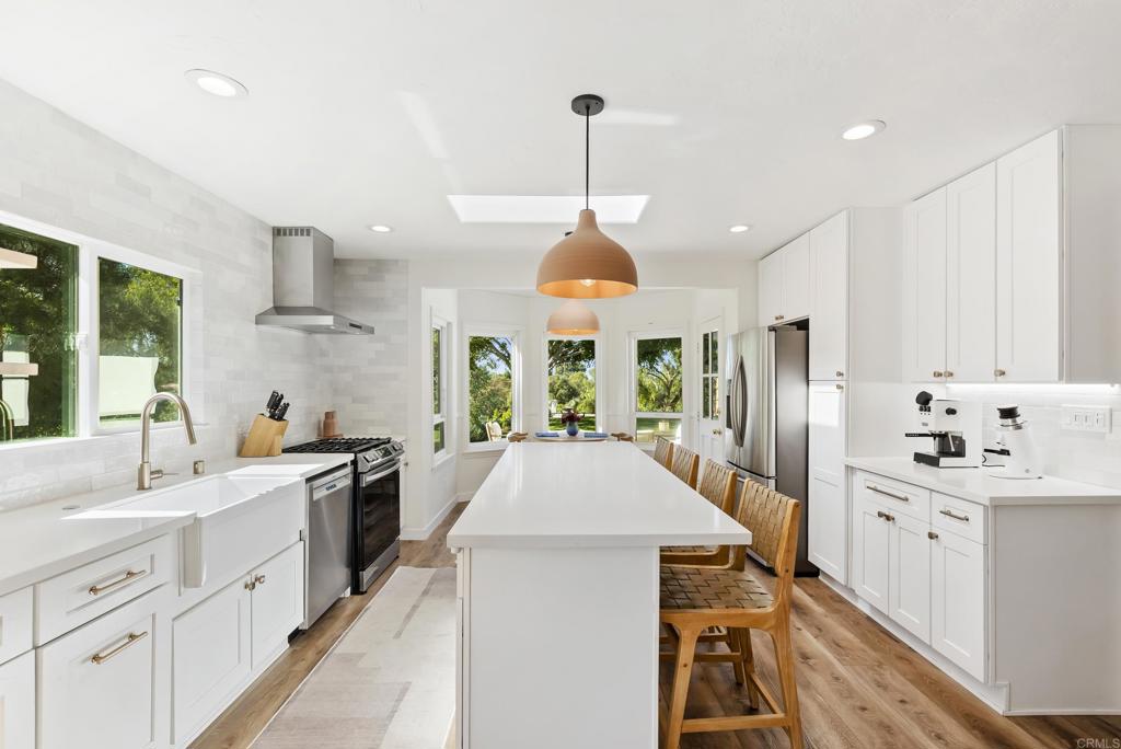 1427 Avocado Road Oceanside, CA 92054 - Photo 22 of 57 a large kitchen with kitchen island a large window a sink and stainless steel appliances