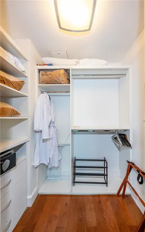 a view of walk in closet with clothes and shoes