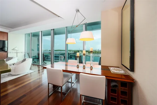 a dining room with furniture a chandelier and wooden floor
