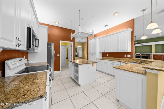 a kitchen with stainless steel appliances granite countertop a sink refrigerator and cabinets