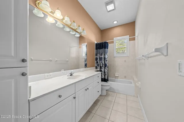 an empty room with ceiling fan and window