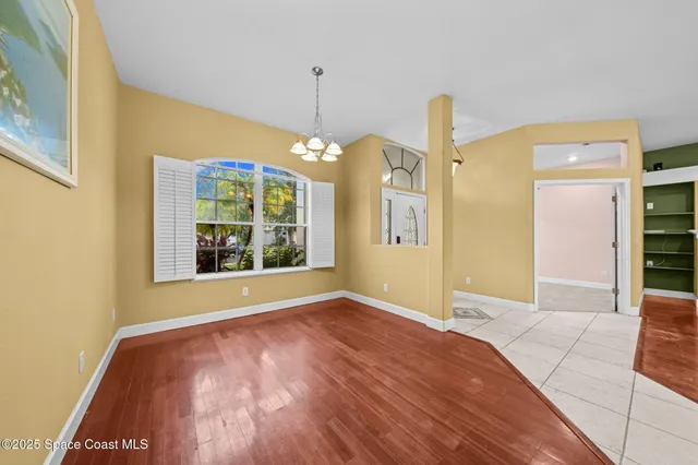 a view of a big room with wooden floor and windows