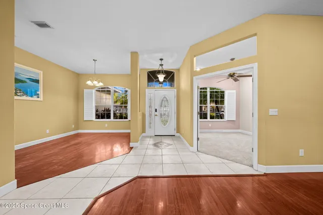 a view of a hallway with wooden floor and a living room