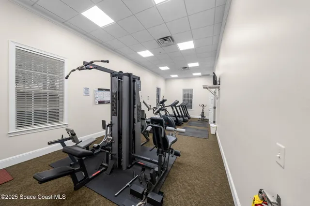 a view of a room with gym equipment and windows