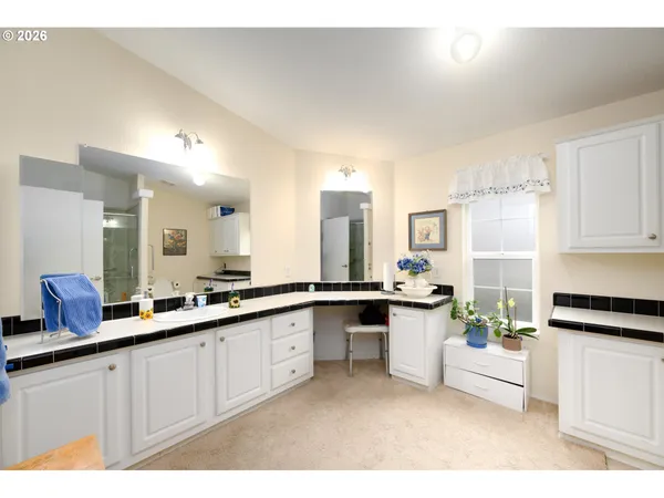 a large white kitchen with a sink and cabinets
