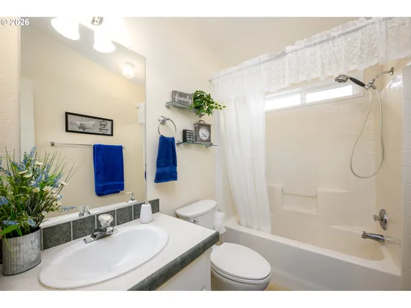 a bathroom with a sink double vanity granite tub shower and a mirror