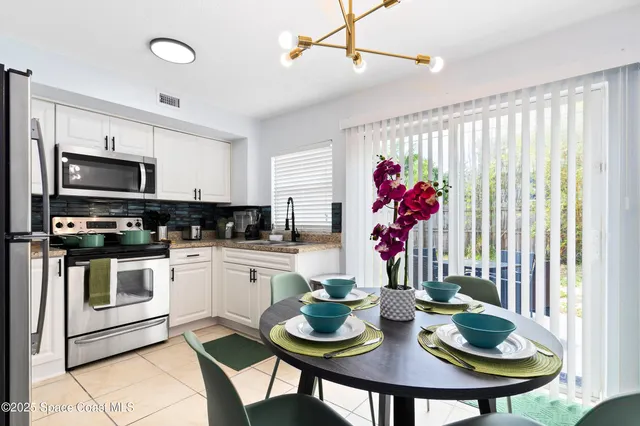 a kitchen with stainless steel appliances kitchen island granite countertop a table and chairs in it