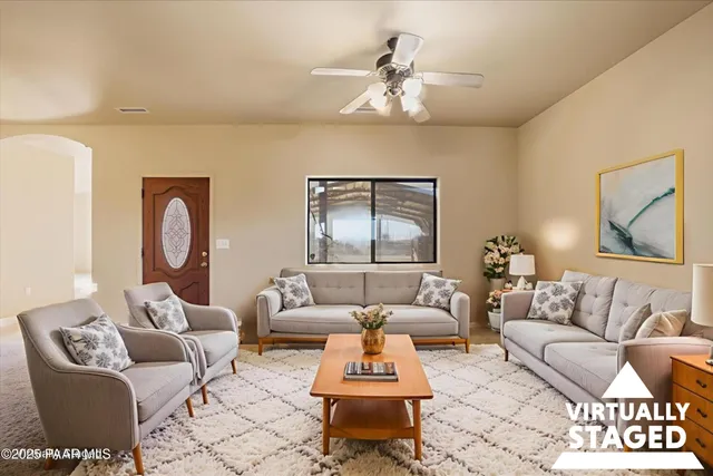 a living room with furniture a rug and wall painting
