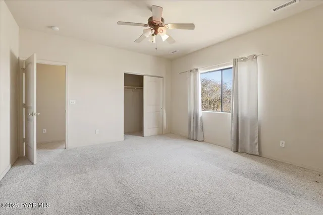a view of a room with a ceiling fan and a window