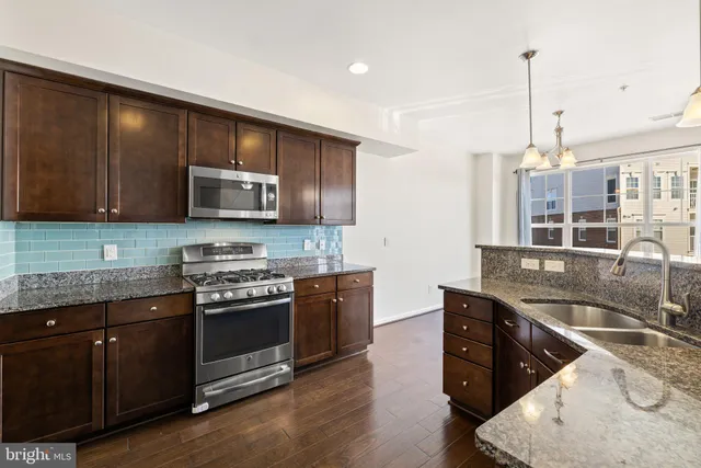 a kitchen with stainless steel appliances granite countertop a sink and stove top oven
