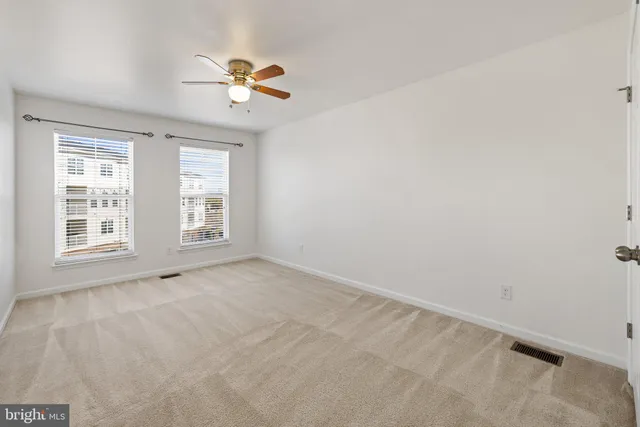 an empty room with closet and fan