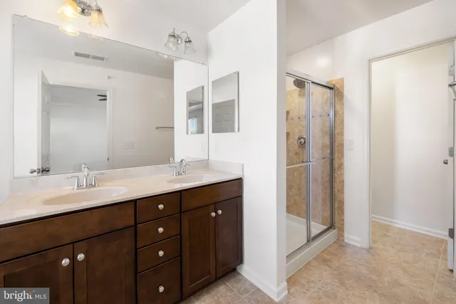 a bathroom with a tub double sink window and mirror