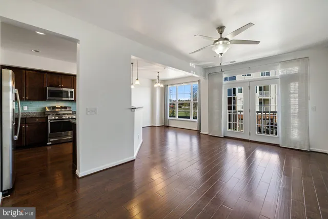 a view of a kitchen with a sink a refrigerator and wooden floor
