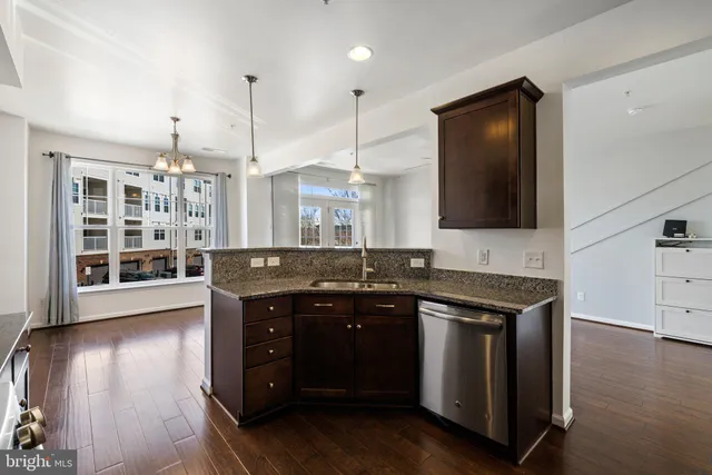 a kitchen with stainless steel appliances granite countertop a sink a stove and a wooden floors