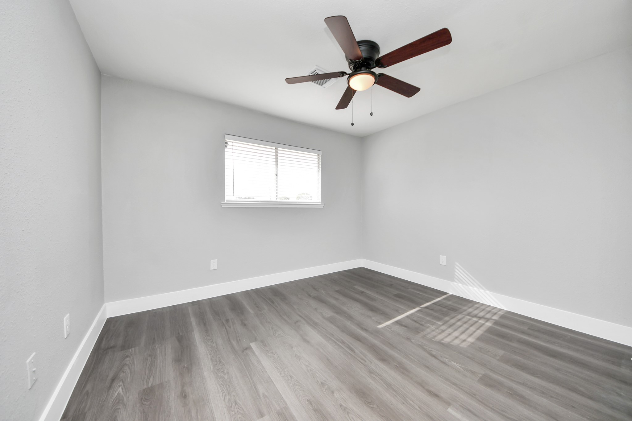 15423 Ridingwood Drive Houston, TX 77489 - Photo 32 of 43 an empty room with wooden floor ceiling fan and windows