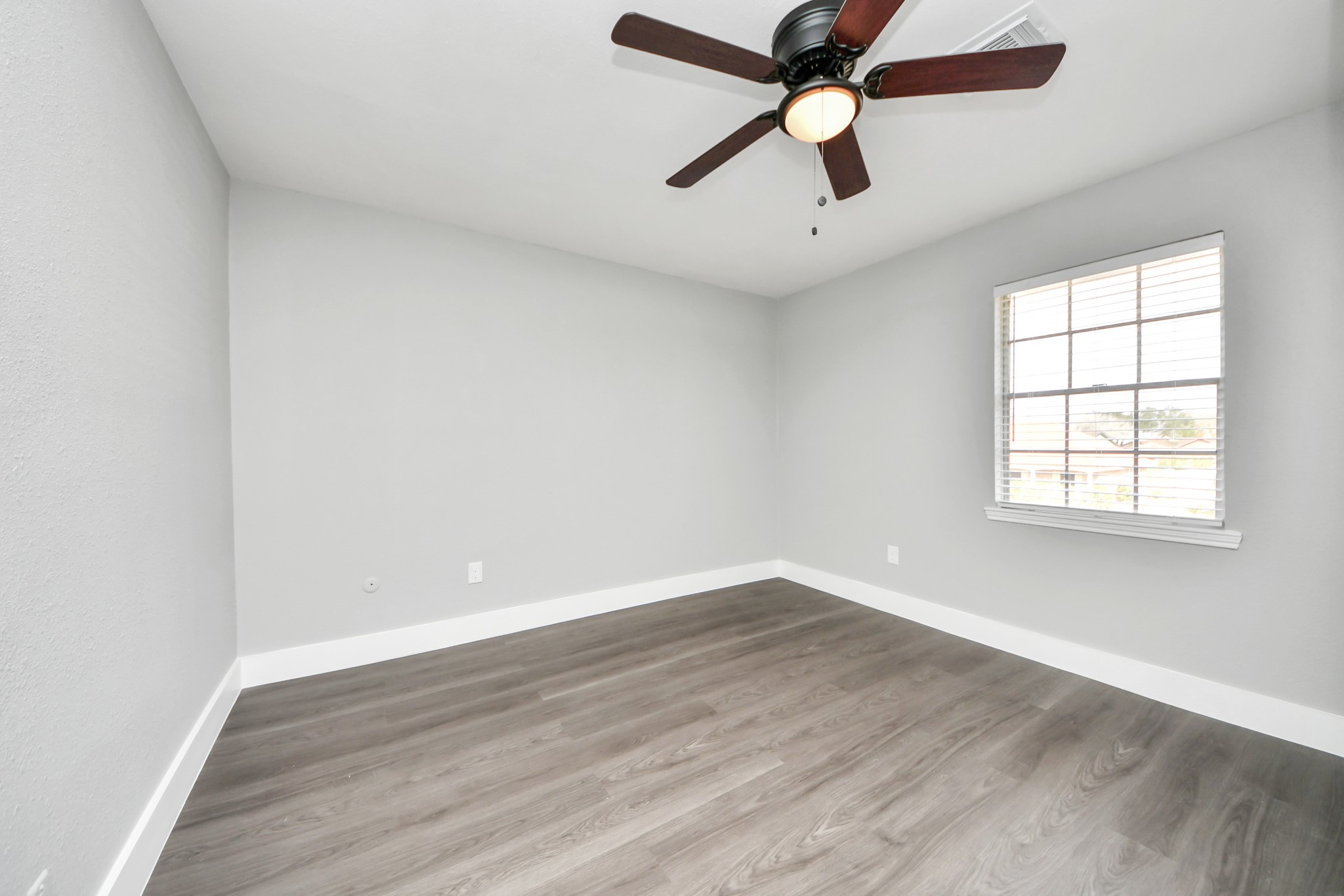 15423 Ridingwood Drive Houston, TX 77489 - Photo 36 of 43 an empty room with wooden floor ceiling fan and windows