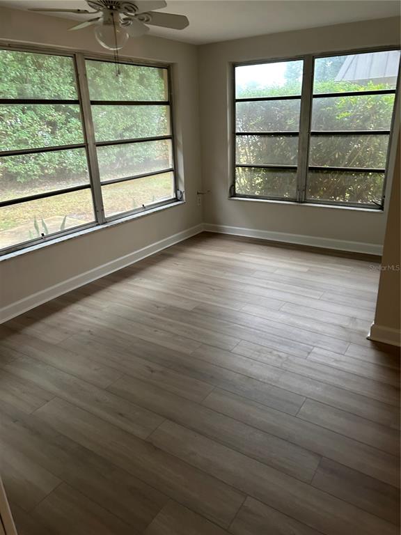 4422 Sunstate Drive New Port Richey, FL 34652 - Photo 15 of 19 an empty room with wooden floor and windows