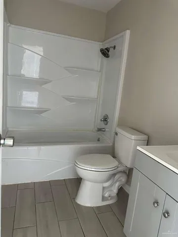 a white toilet sitting next to a bath tub