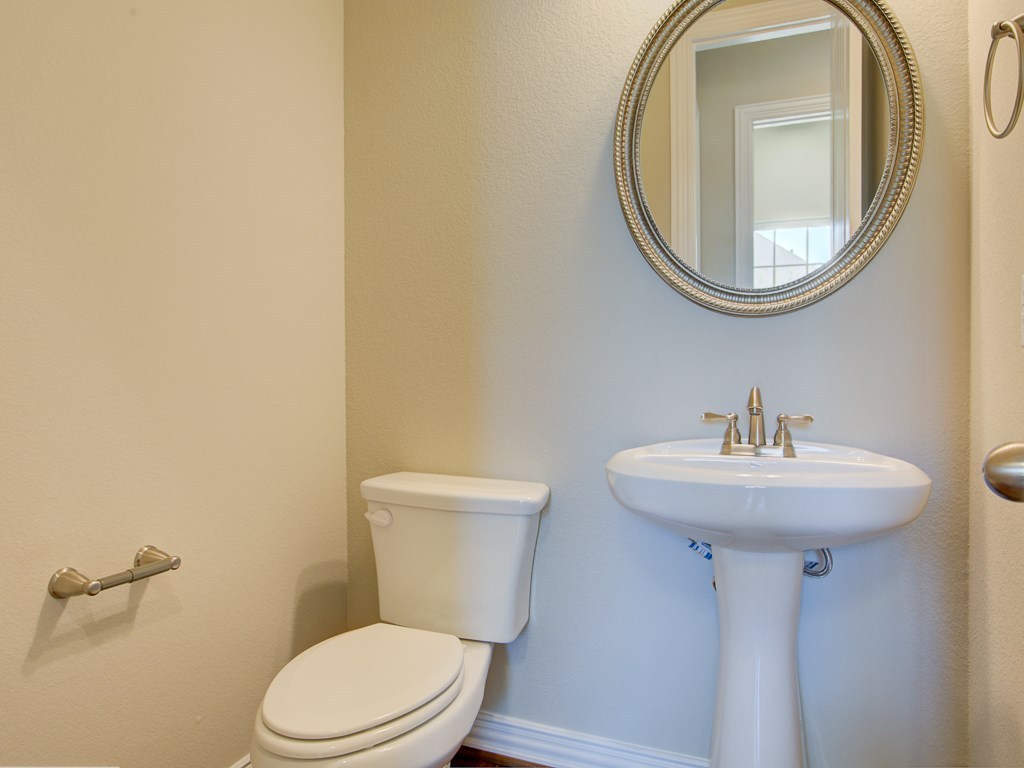 4303 Logan Ridge Drive Cedar Park, TX 78613 - Photo 22 of 24 Pedestal sink with brushed nickel faucet, complemented by an ornate framed circular mirror