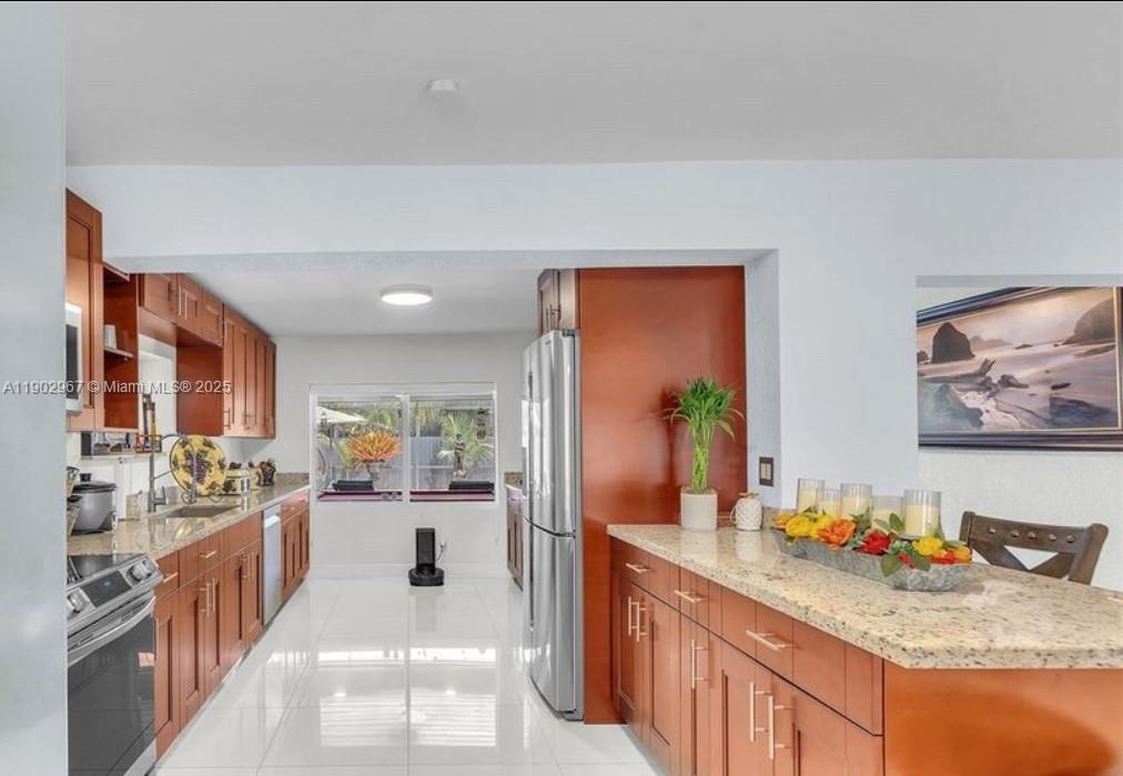 16891 Southwest 277th Street Homestead, FL 33031 - Photo 13 of 47 a kitchen with stainless steel appliances kitchen island granite countertop a stove a sink and a refrigerator