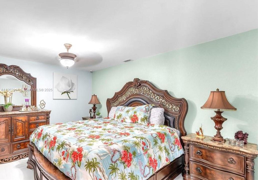16891 Southwest 277th Street Homestead, FL 33031 - Photo 20 of 47 a bedroom with a bed and a lamp on dresser