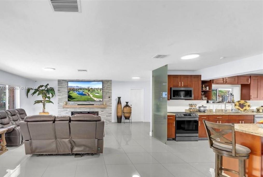 16891 Southwest 277th Street Homestead, FL 33031 - Photo 6 of 47 a living room with stainless steel appliances kitchen island furniture and a flat screen tv