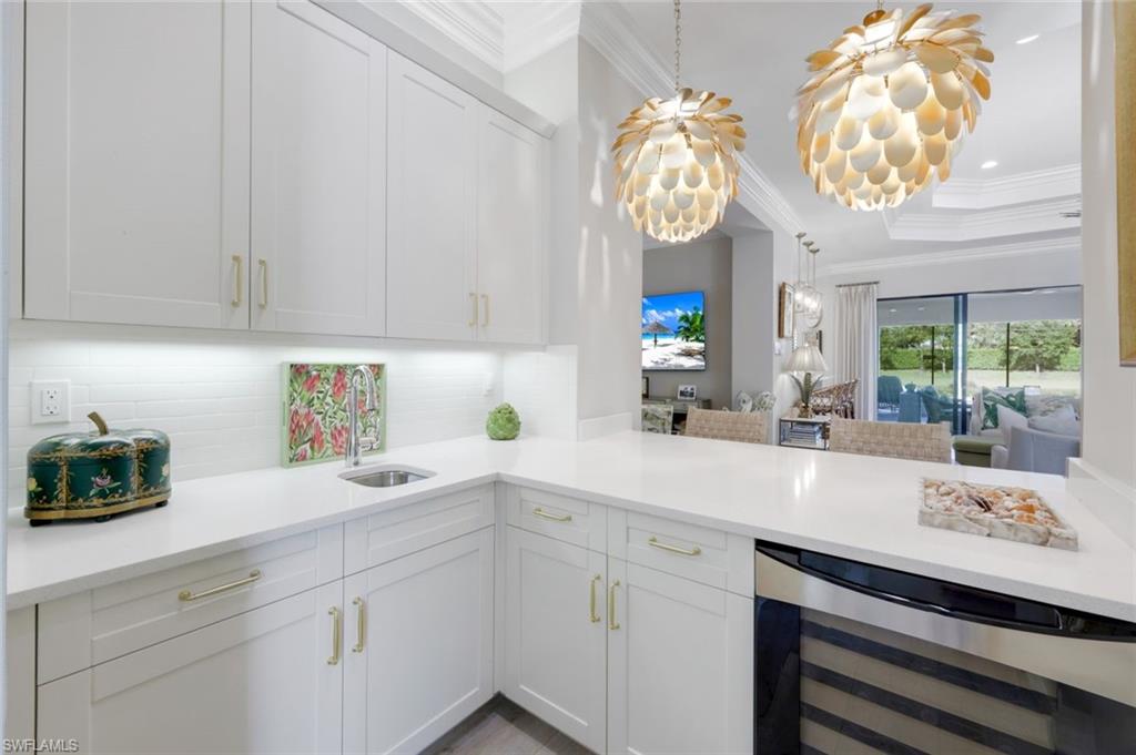 4478 Caldera Circle Naples, FL 34119 - Photo 4 of 50 Bar area with spectacular pendants, wine/drink refrigerator and sink offers service near the great room away from the kitchen