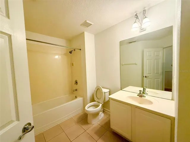 a bathroom with a granite countertop sink a toilet a mirror and shower