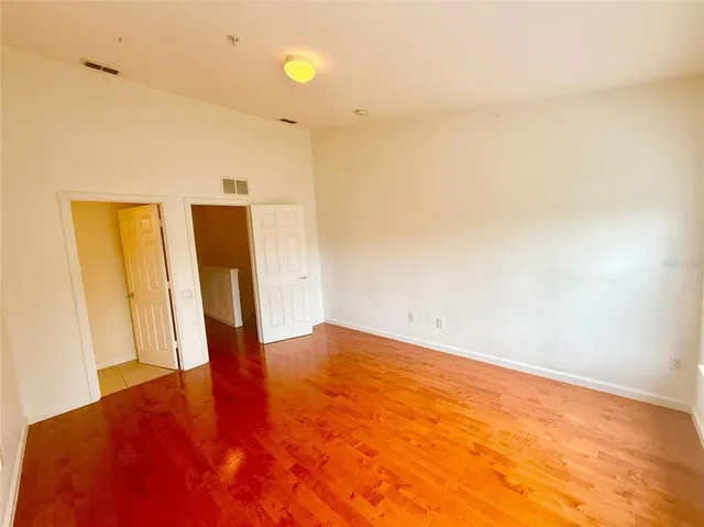 a view of empty room with wooden floor