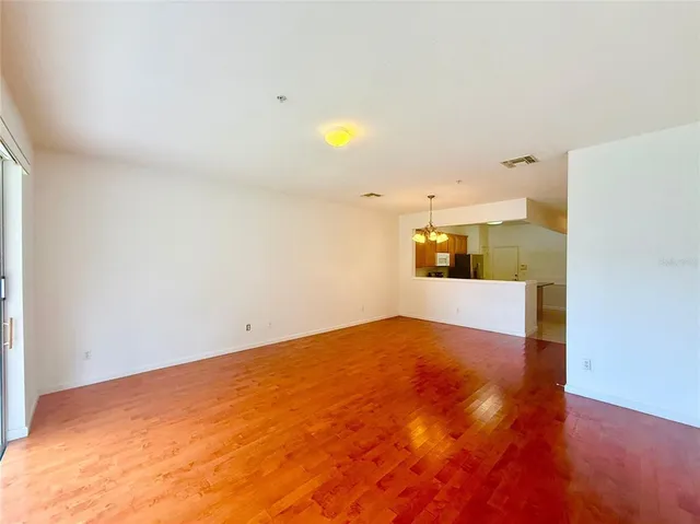 a view of a big room with wooden floor and windows