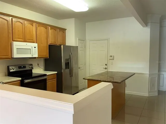a kitchen with stainless steel appliances granite countertop a refrigerator and a stove top oven