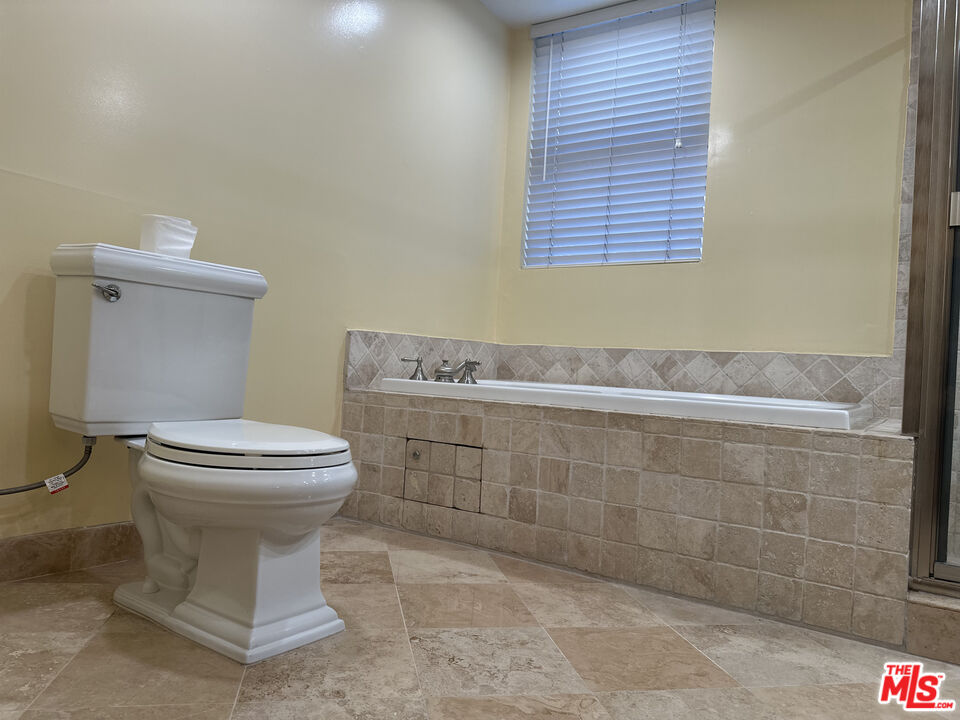 122 North Clark Drive, Unit 105 West Hollywood, CA 90048 - Photo 22 of 28 a bathroom with a toilet sink and mirror