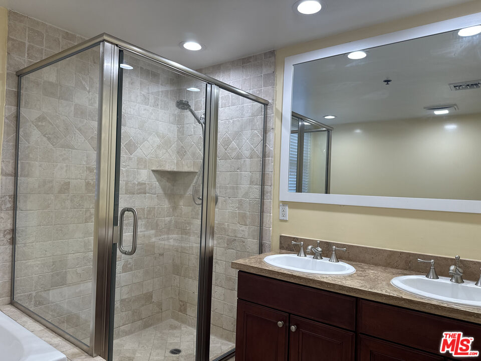 122 North Clark Drive, Unit 105 West Hollywood, CA 90048 - Photo 23 of 28 a bathroom with a double vanity sink mirror and shower