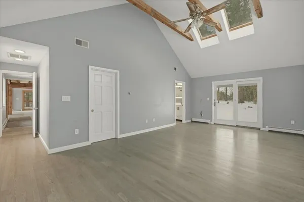 an empty room with wooden floor and windows