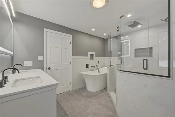 a large white kitchen with a sink a toilet and a mirror
