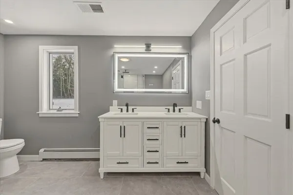 a bathroom with a sink vanity and a mirror