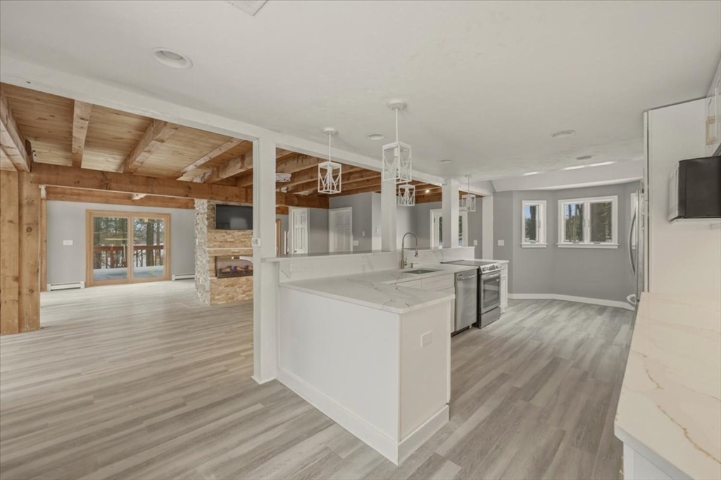 98 Walnut Street Halifax, MA 02338 - Photo 4 of 36 a kitchen with stainless steel appliances kitchen island wooden floors and view living room