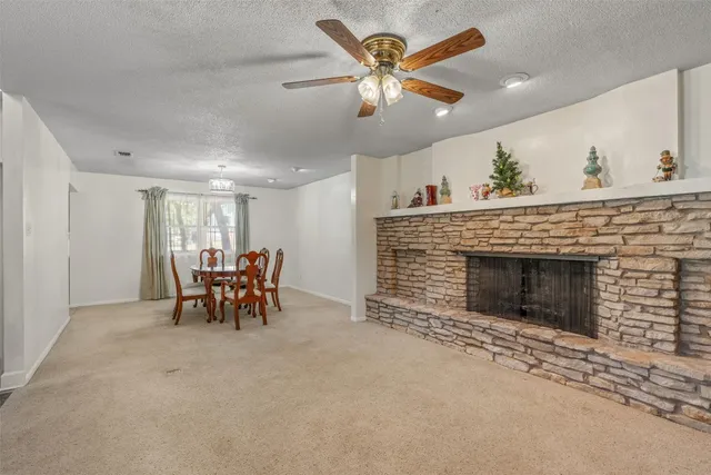 an empty room with fireplace and fan