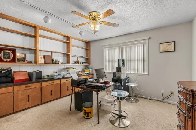 a view of a workspace with furniture and a window
