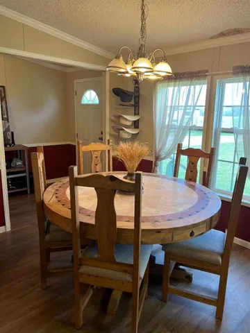 a view of a dining room with furniture wooden floor and chandelier