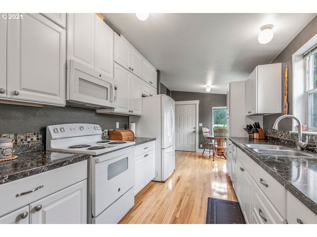 109 Highland Road Winlock, WA 98596 - Photo 18 of 28 a kitchen with granite countertop a sink stainless steel appliances and cabinets