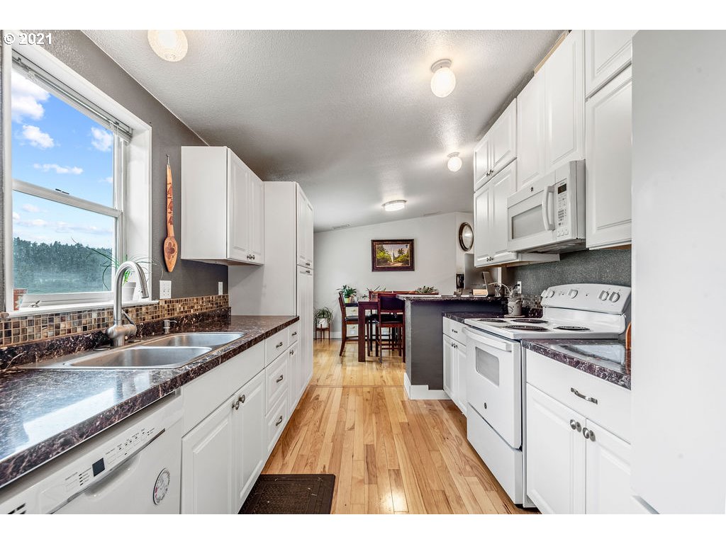 109 Highland Road Winlock, WA 98596 - Photo 19 of 28 a large kitchen with stainless steel appliances granite countertop a lot of counter space and a sink