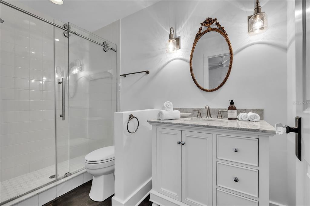 8241 Main Street Bokeelia, FL 33922 - Photo 51 of 100 a bathroom with a granite countertop toilet sink and a mirror