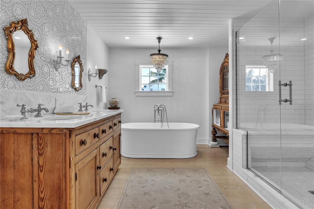 8241 Main Street Bokeelia, FL 33922 - Photo 65 of 100 a spacious bathroom with a double vanity sink mirror and bathtub
